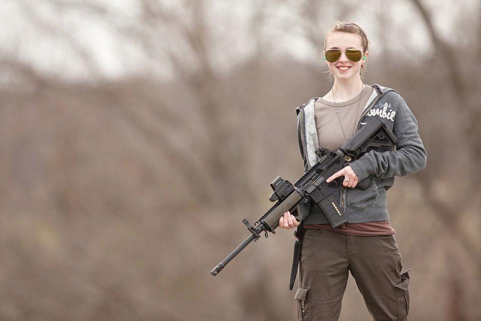 a girl pose her rifle